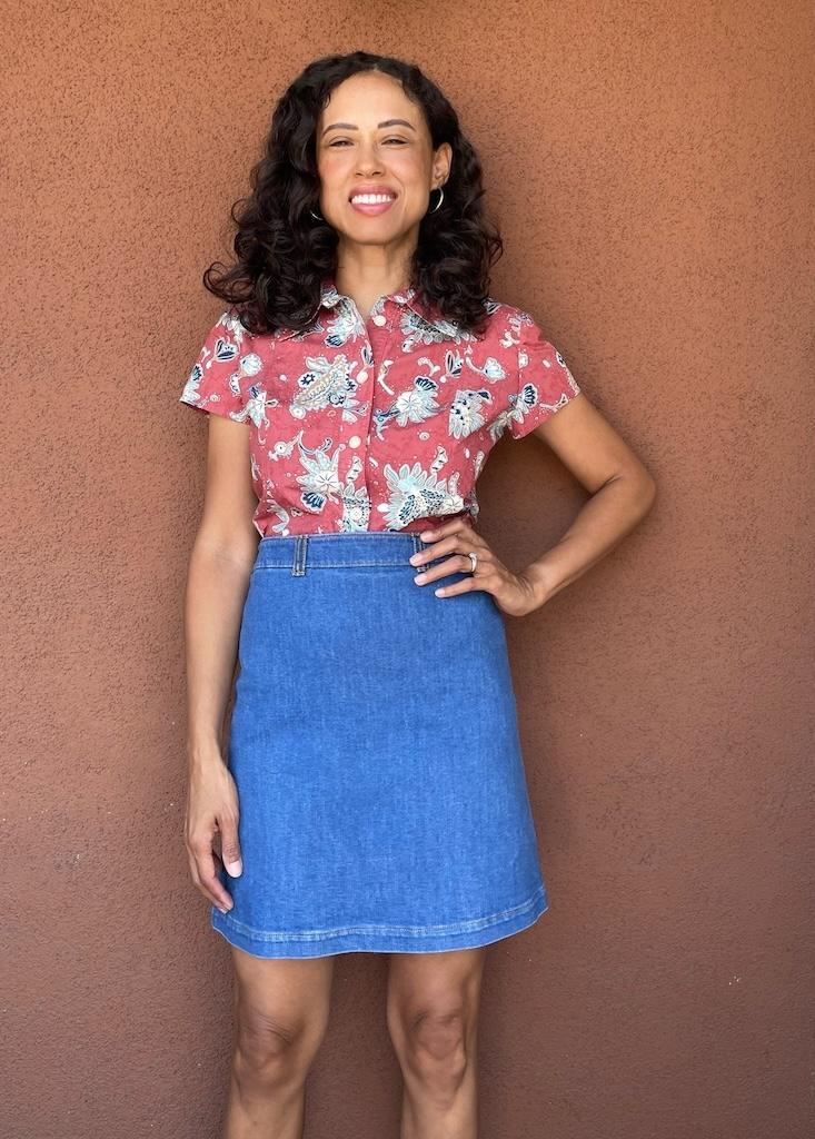 Luna smiling to the camera with hand on hip, wearing button up shirt  and diy denim skirt 