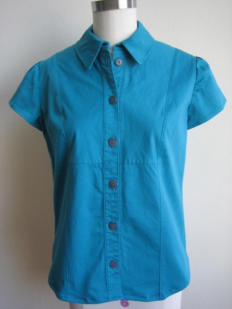 Front view of Luna’s handmade shirt in torquoise fabric on the dress form, made with Simplicity S2447