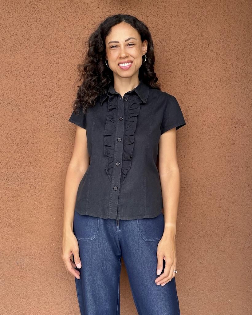Front view of Luna smiling, wearing her handmade shirt in black fabric and ruffles, made with Simplicity S2447