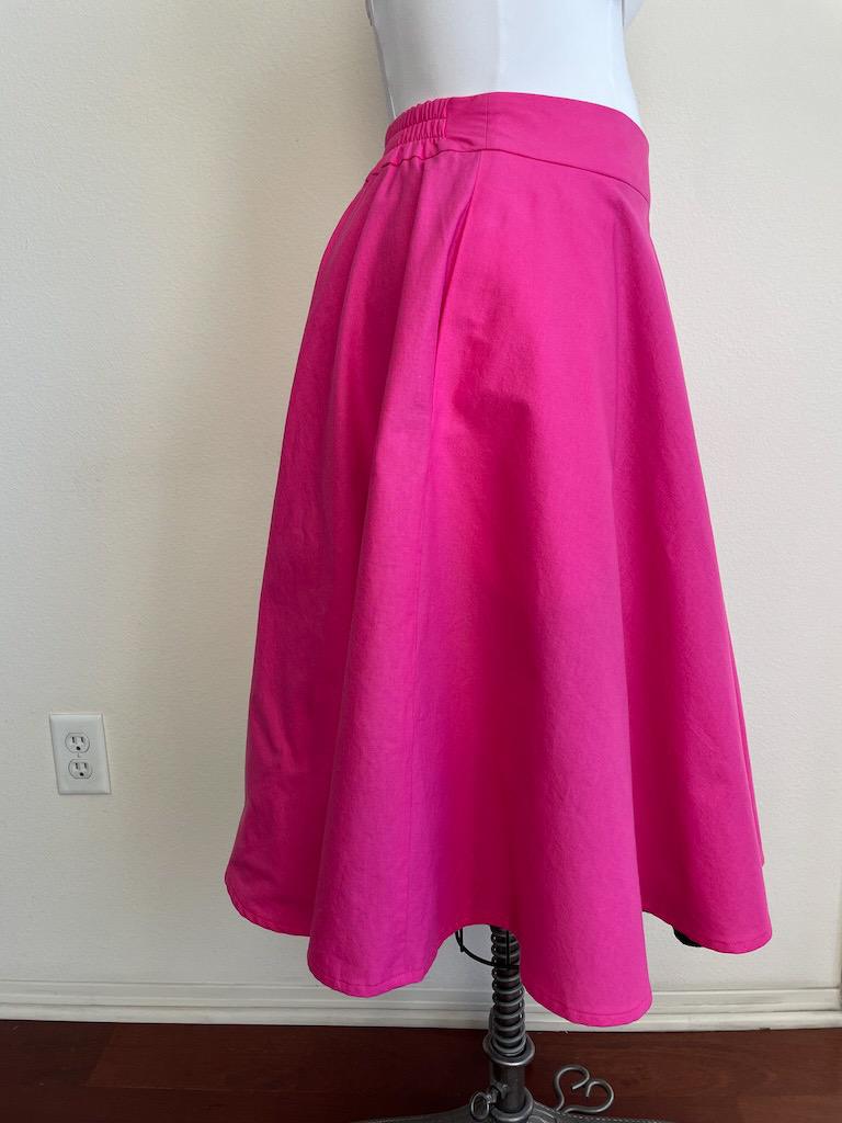 Side view Luna’s handmade sock hop skirt in bright pink fabric made from two sewing patterns