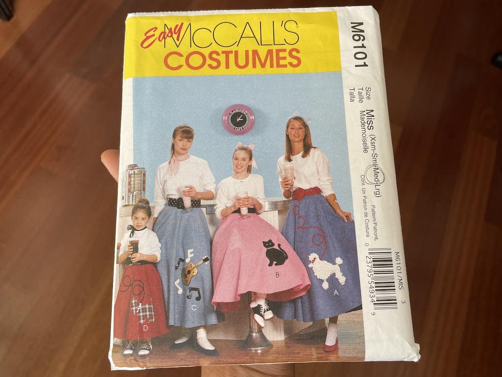 Luna holding McCall’s sock hop skirt pattern envelope to make a 50s style costume
