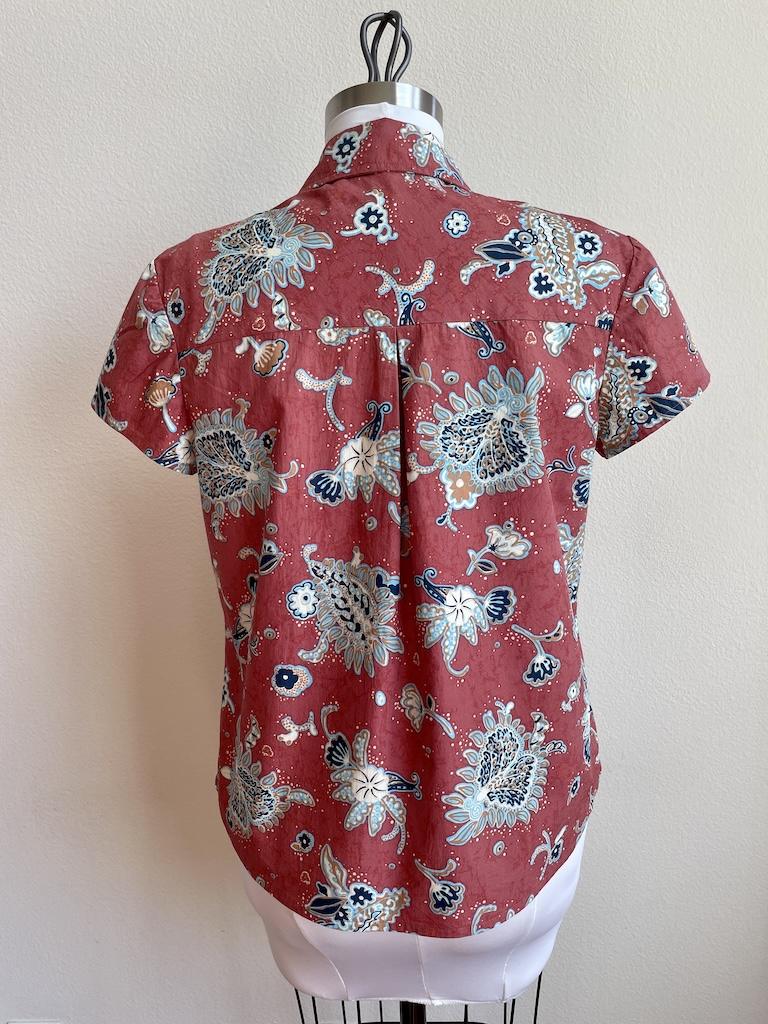 Back view of Luna’s button-up shirt made with Simplicity S2447 pattern in cotton floral fabric on the dress form