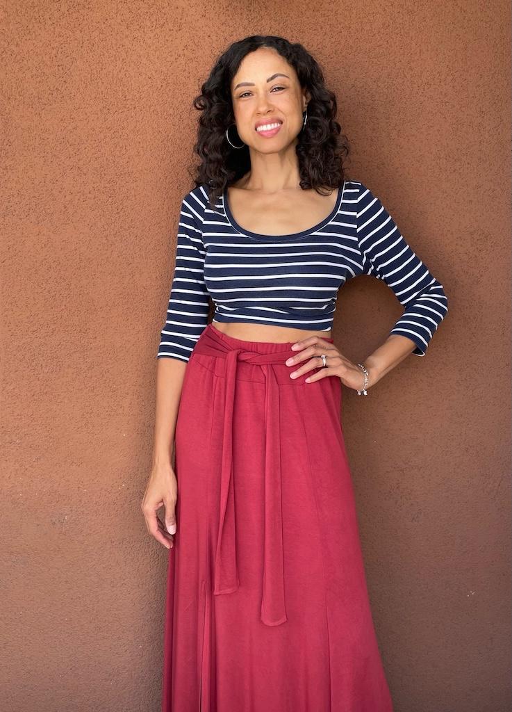 Luna smiling with hand on hip wearing her top and skirt made with sewing patterns.