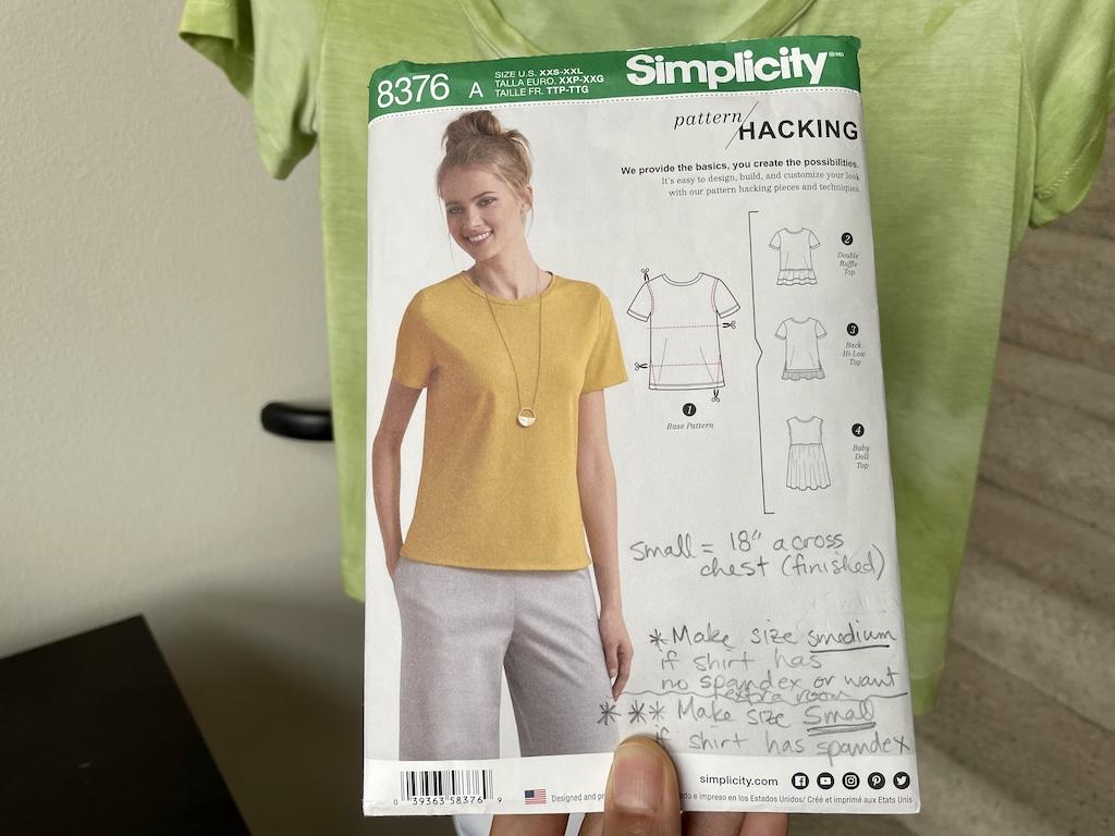 Luna’s hand holding up Simplicity S8376 T-shirt sewing pattern envelope