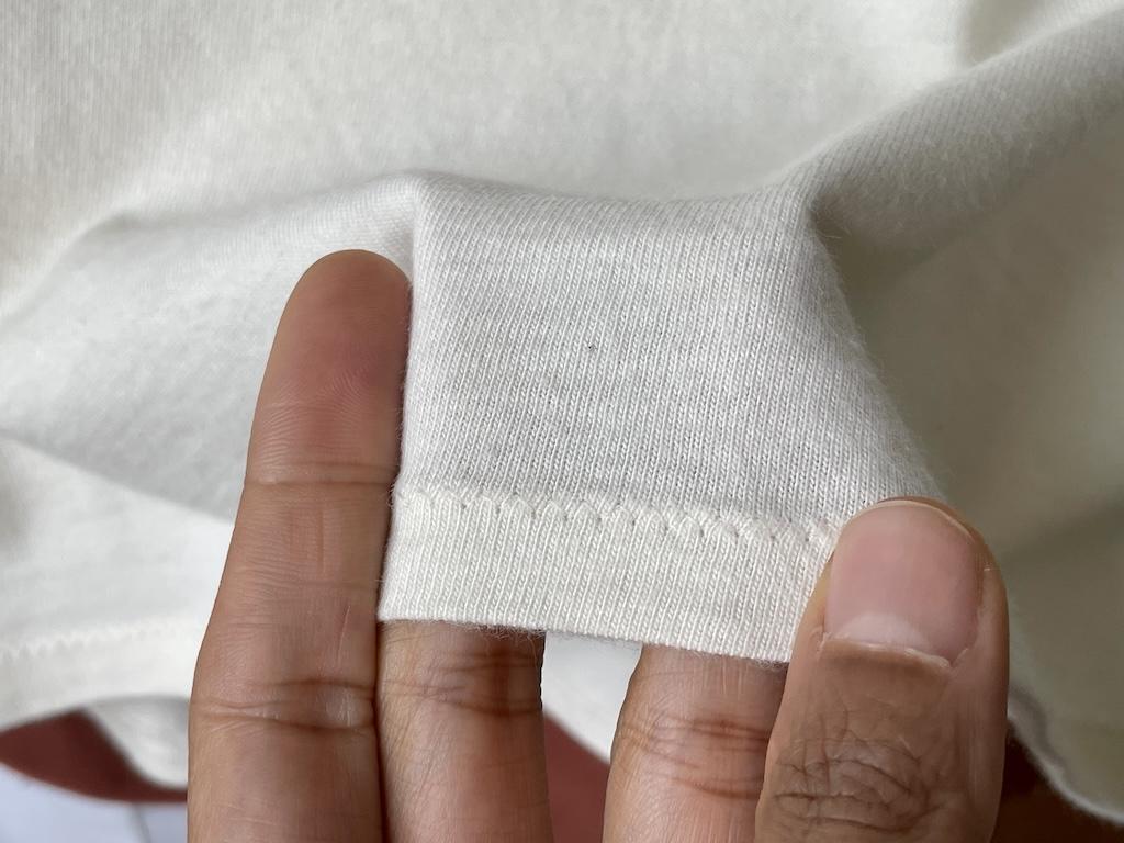 Close up of Luna’s hand showing zig-zag stitches on her T-shirt made of cotton knit