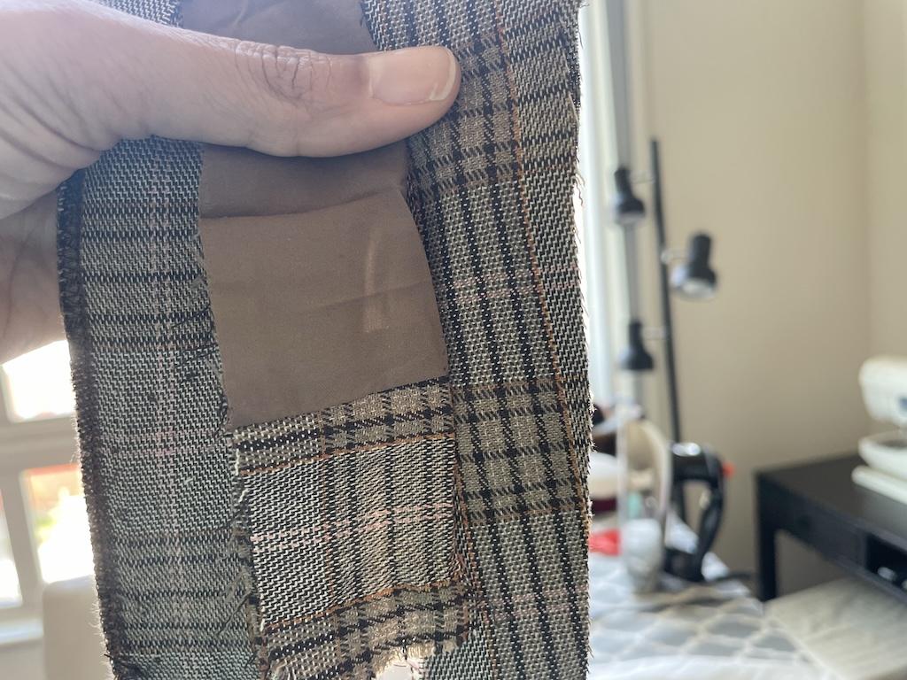 Luna’s hand holding up polyester blend fabric that caused her fabric allergies