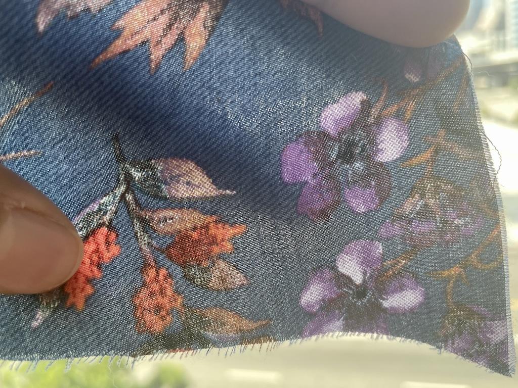 Close up of tencel twill fabric held up to sunlight that Luna used to make her dress