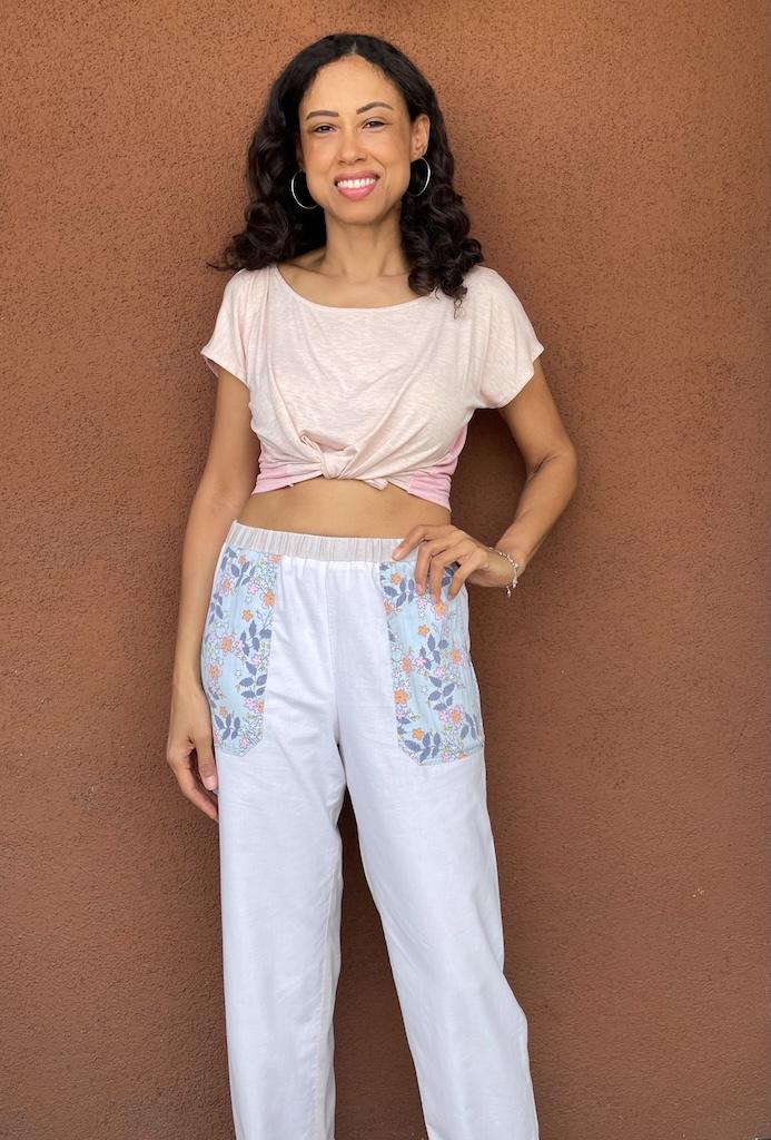 Luna smiling to the camera with hand on hip wearing her pants mockup with floral design pockets
