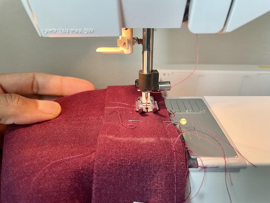 Close up view of Luna stitching the casing of her pants with her sewing machine