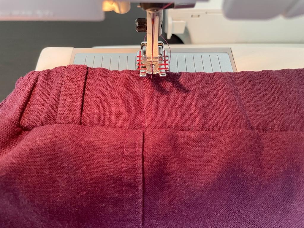 Close up view of Luna’s machine sewing the elastic waistband on her pants