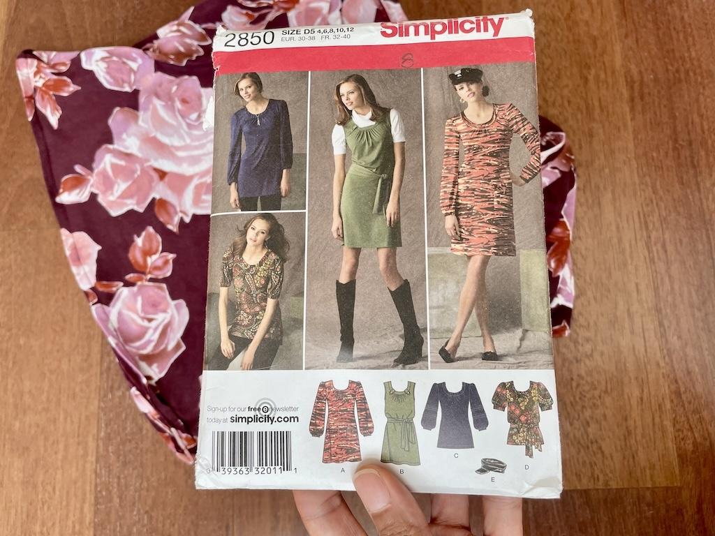 Luna’s hand holding Simplicity S2850 sewing pattern envelope for dresses and tops