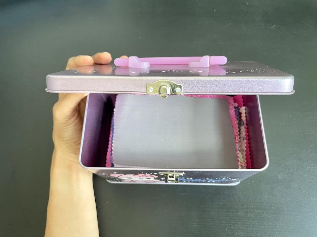View of inside Luna’s metal container with her DIY fabric swatches stored inside