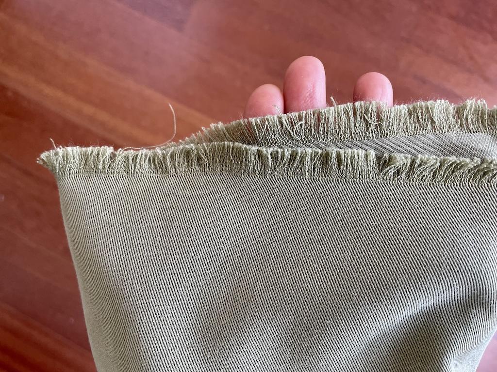Close up view of green tencel twill fabric Luna used to sew her coat