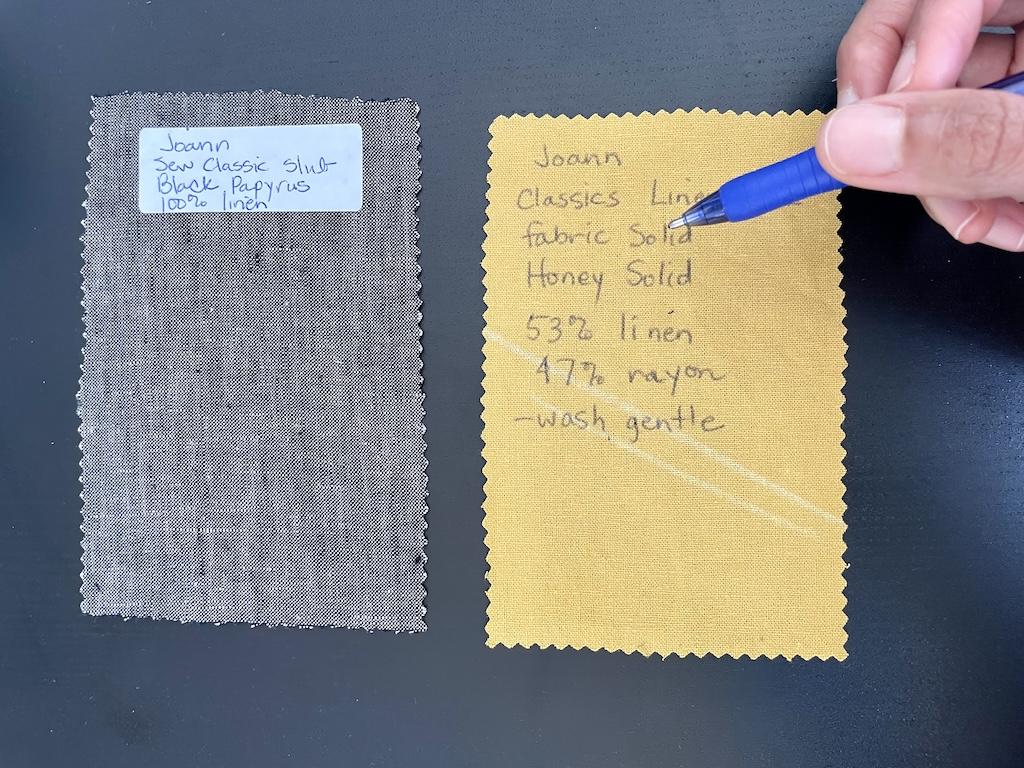 Close up of Luna’s hand holding an ink pen and next to her DIY fabric swatches with information on them