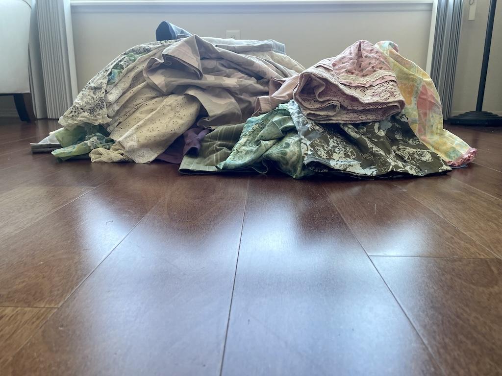 View of DIY clothes that Luna made on the wooden floor of her sewing room