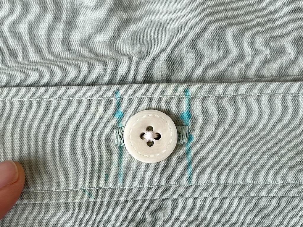 Close up Luna’s fingers and hand sewn button on her DIY shirt