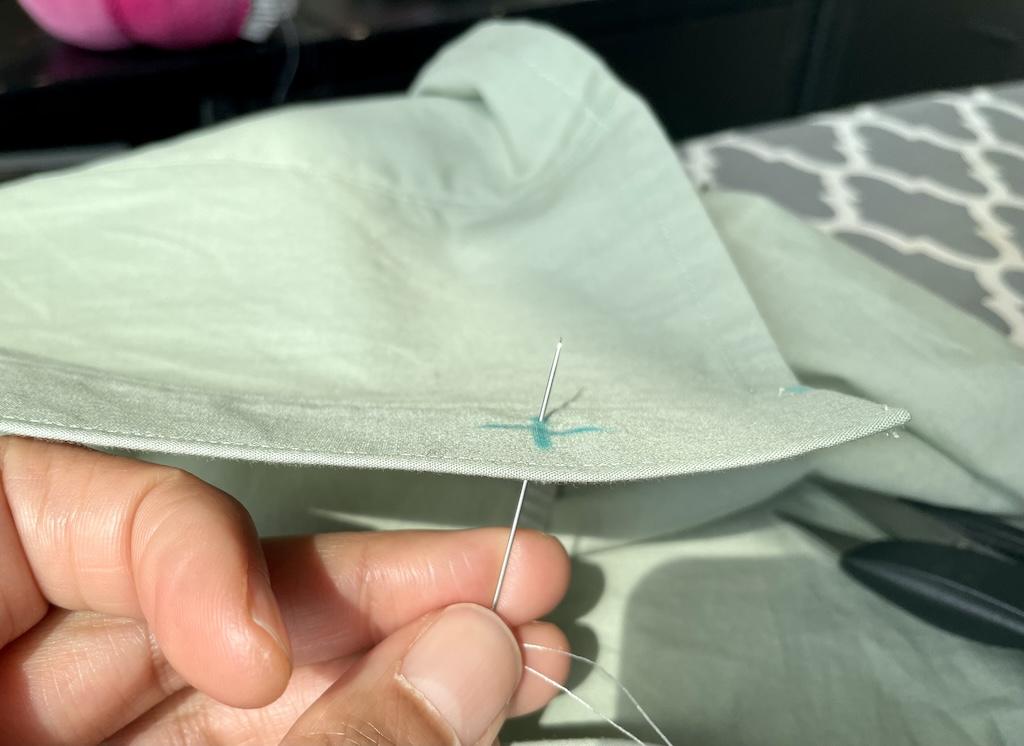 Close up view of Luna’s fingers pushing needle through back side of fabric