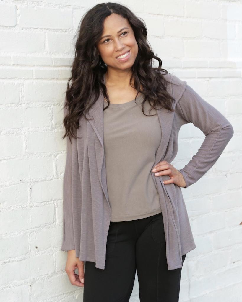 Luna smiling and looking away from the camera wearing her cardigan with hood