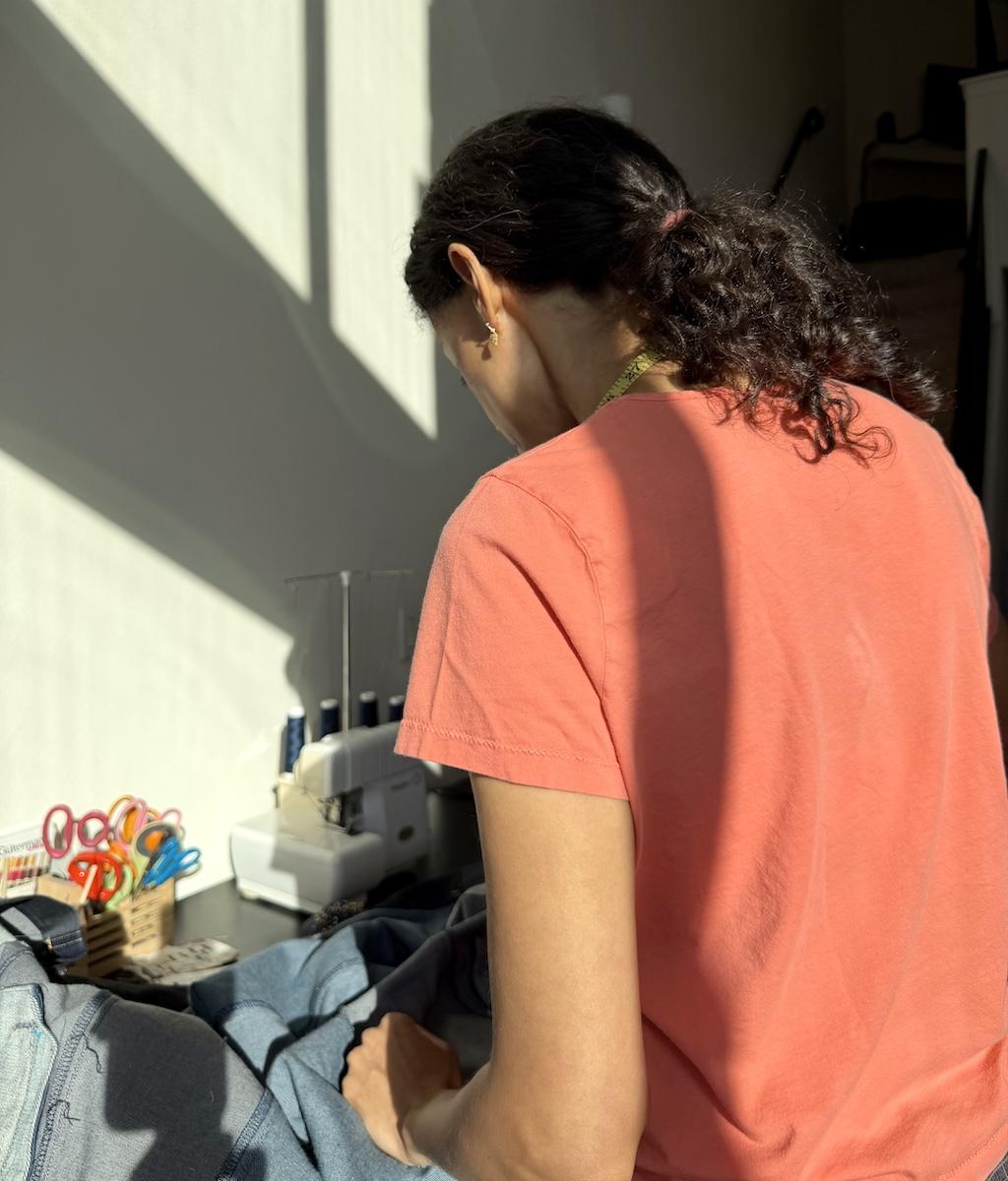 Back view of Luna working in her sewing room with dark shadows on her