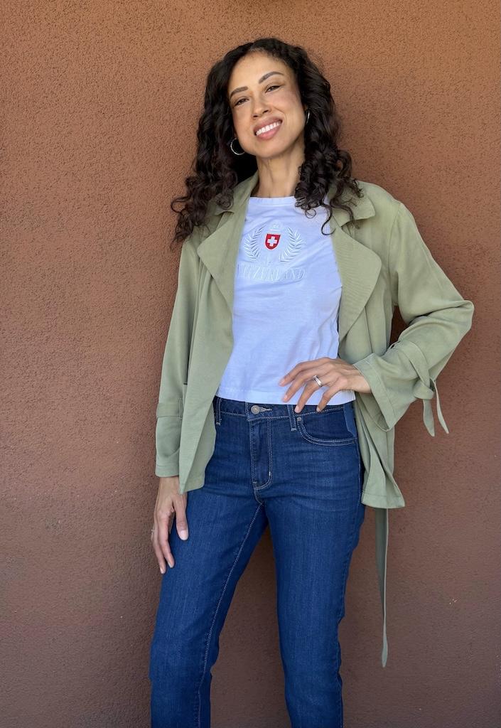 Luna smiling with hand on hip wearing her handmade soft trench coat in green fabric
