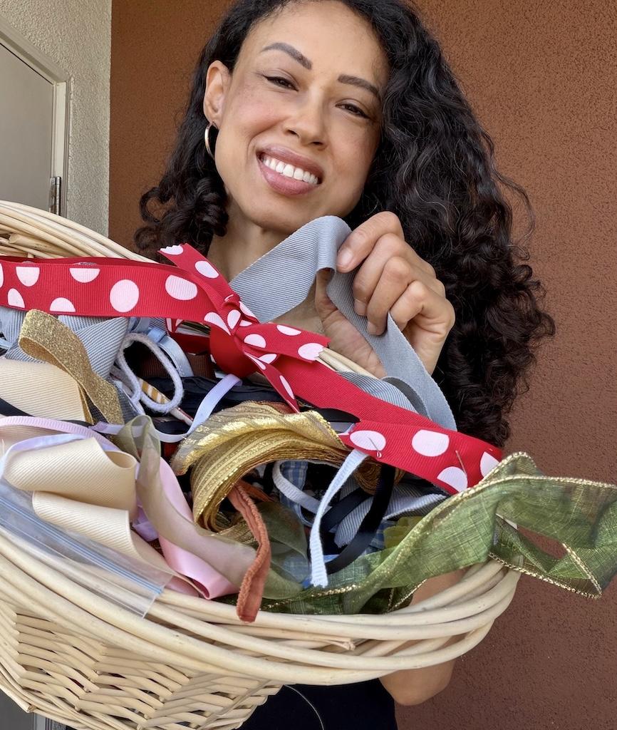 Luna smiling, holding up basket filled with ribbons