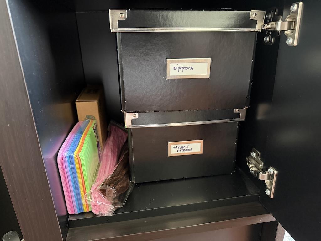 View cardboard storage boxes in cubbie that Luna uses in her sewing room