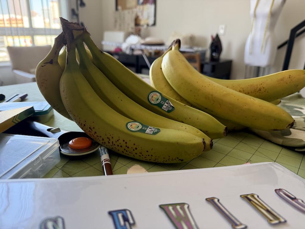 Bunches of bananas in Luna’s sewing room, on cutting table