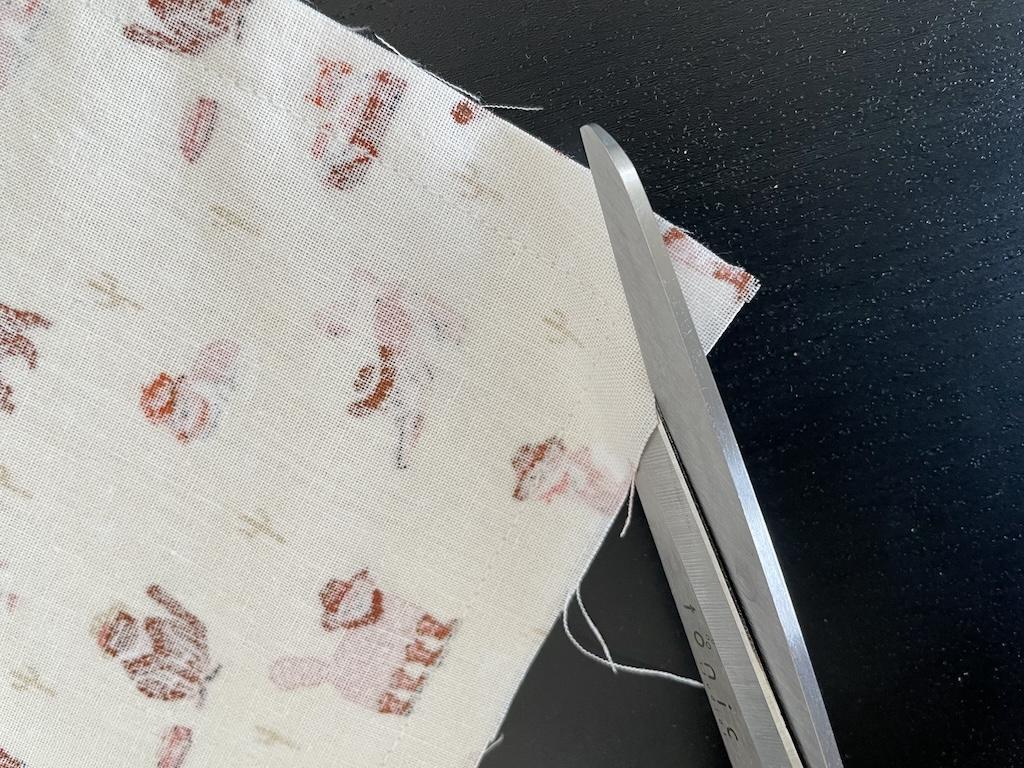 Close up view of scissors clipping corner on diy cloth napkin