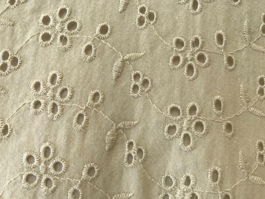 Close up view of cotton eyelet fabric with vine design that Luna used to sew her dress