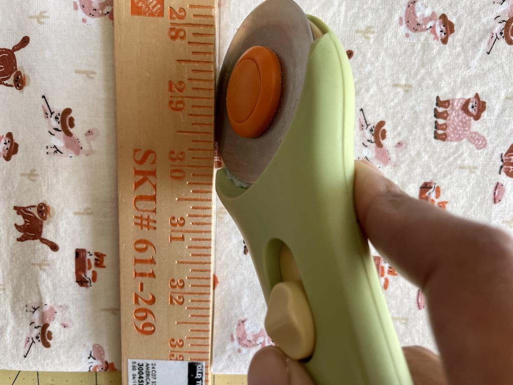 Close up of cutting quilting cotton with rotary cutter