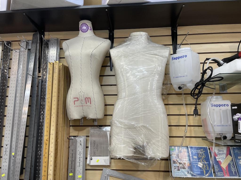 Dress forms hanging on wall in sewing supply shop