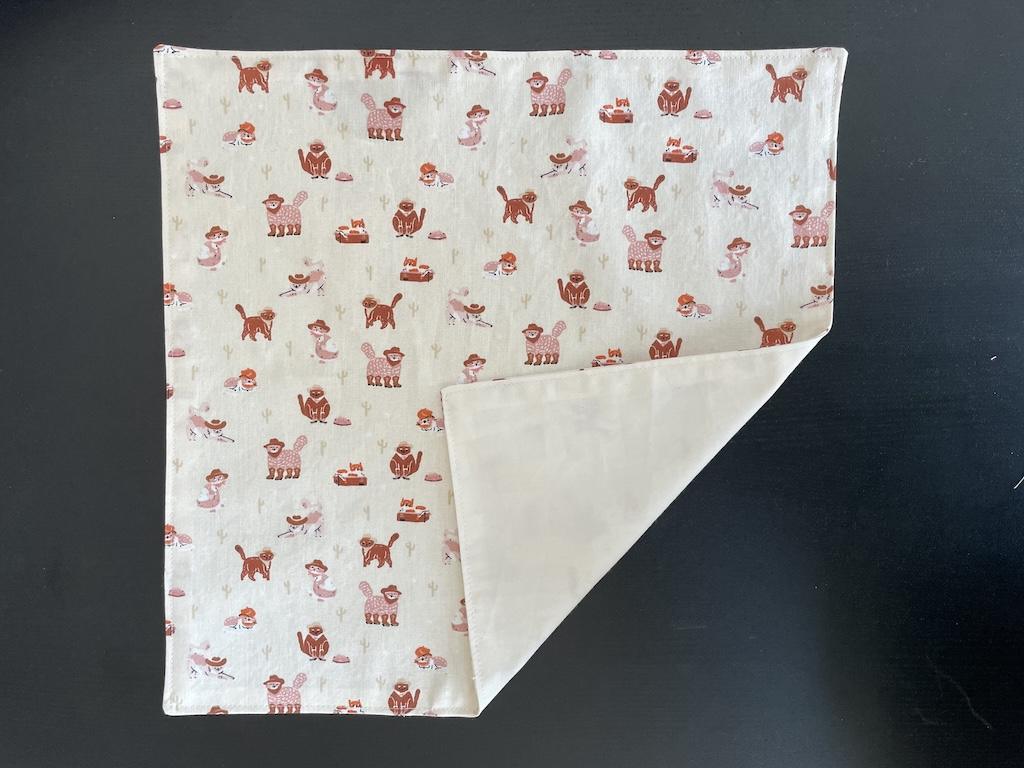 View of DIY reversible fabric napkin that Luna finished, folded at bottom to see the other side