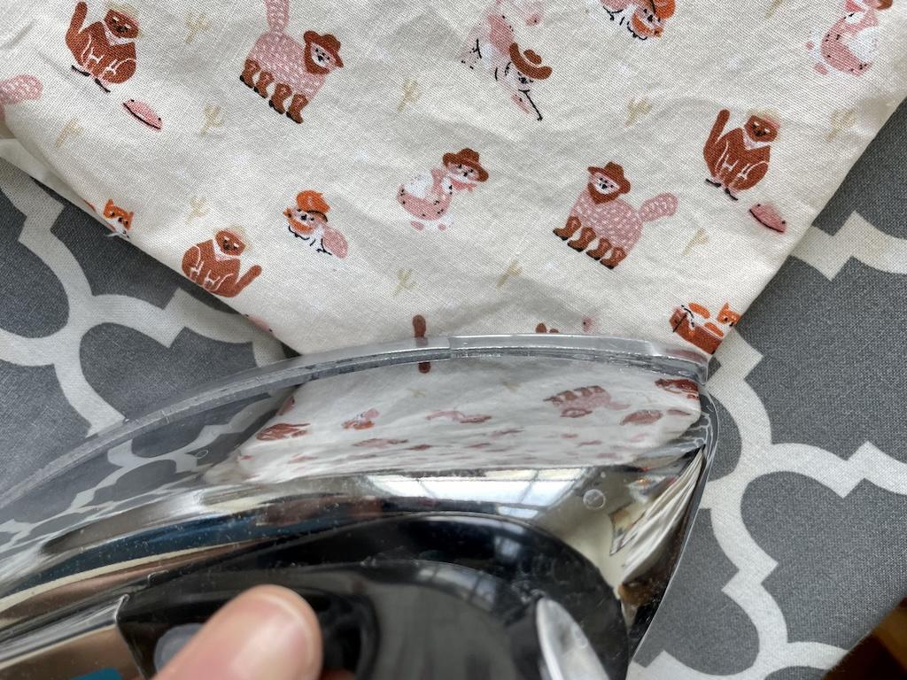 Close up view of Luna ironing DIY reversible cloth napkins after turning them inside out