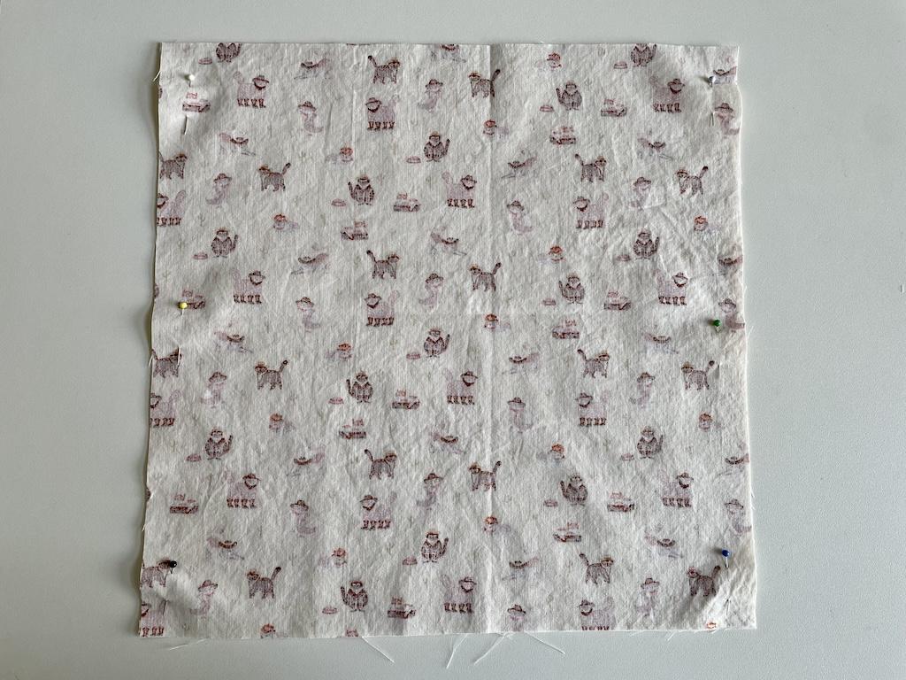 Top view of DIY napkins cut, with right sides facing on cutting table