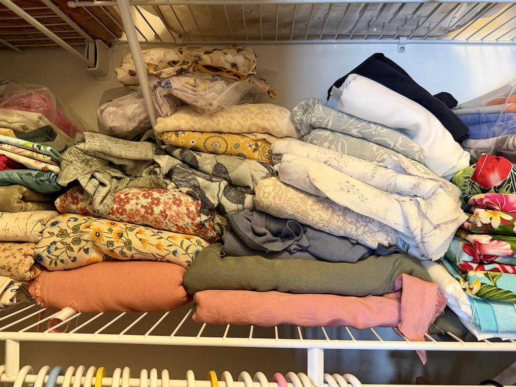View of Luna’s fabric stash for sewing made of rayon materials on the shelf in her closet