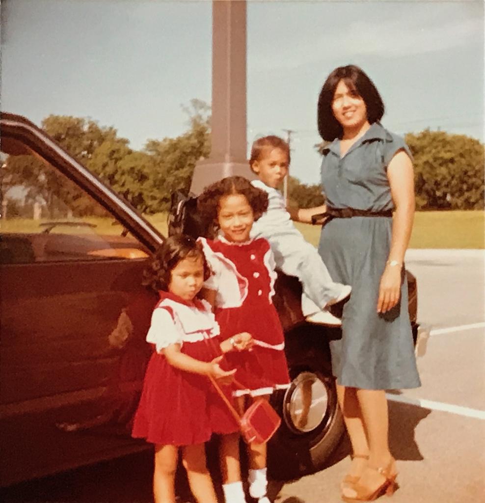 Luna with her siblings and mother, wearing the handmade dresses her mom made