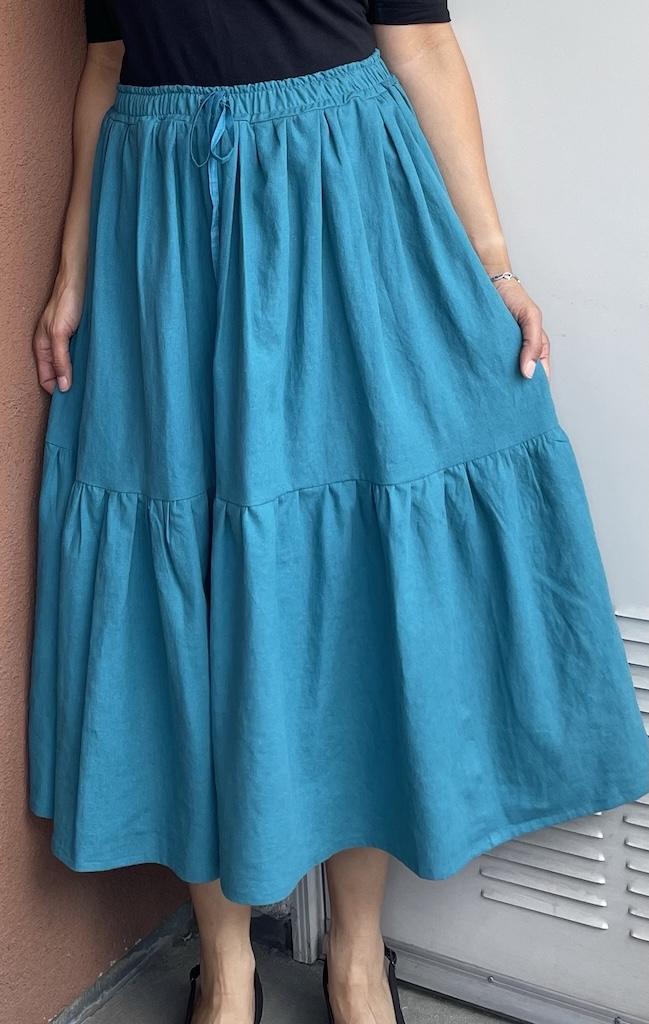 Front view of Luna’s DIY tiered linen maxi skirt, gathered in turquoise fabric