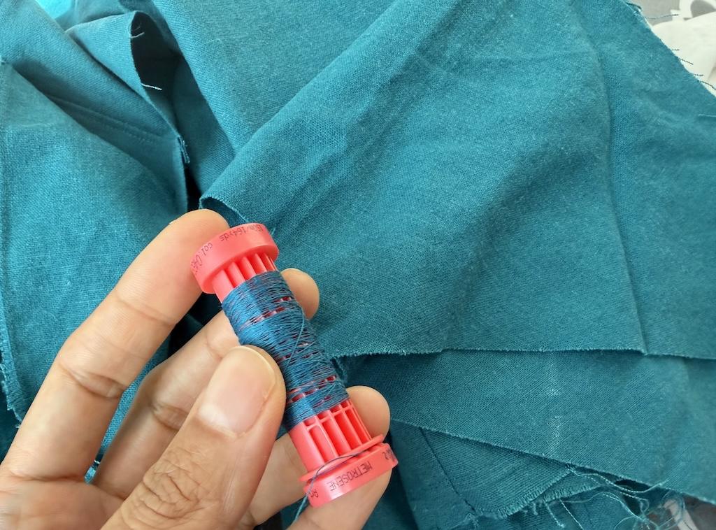 Turquoise linen fabric and thread Luna used to make garment